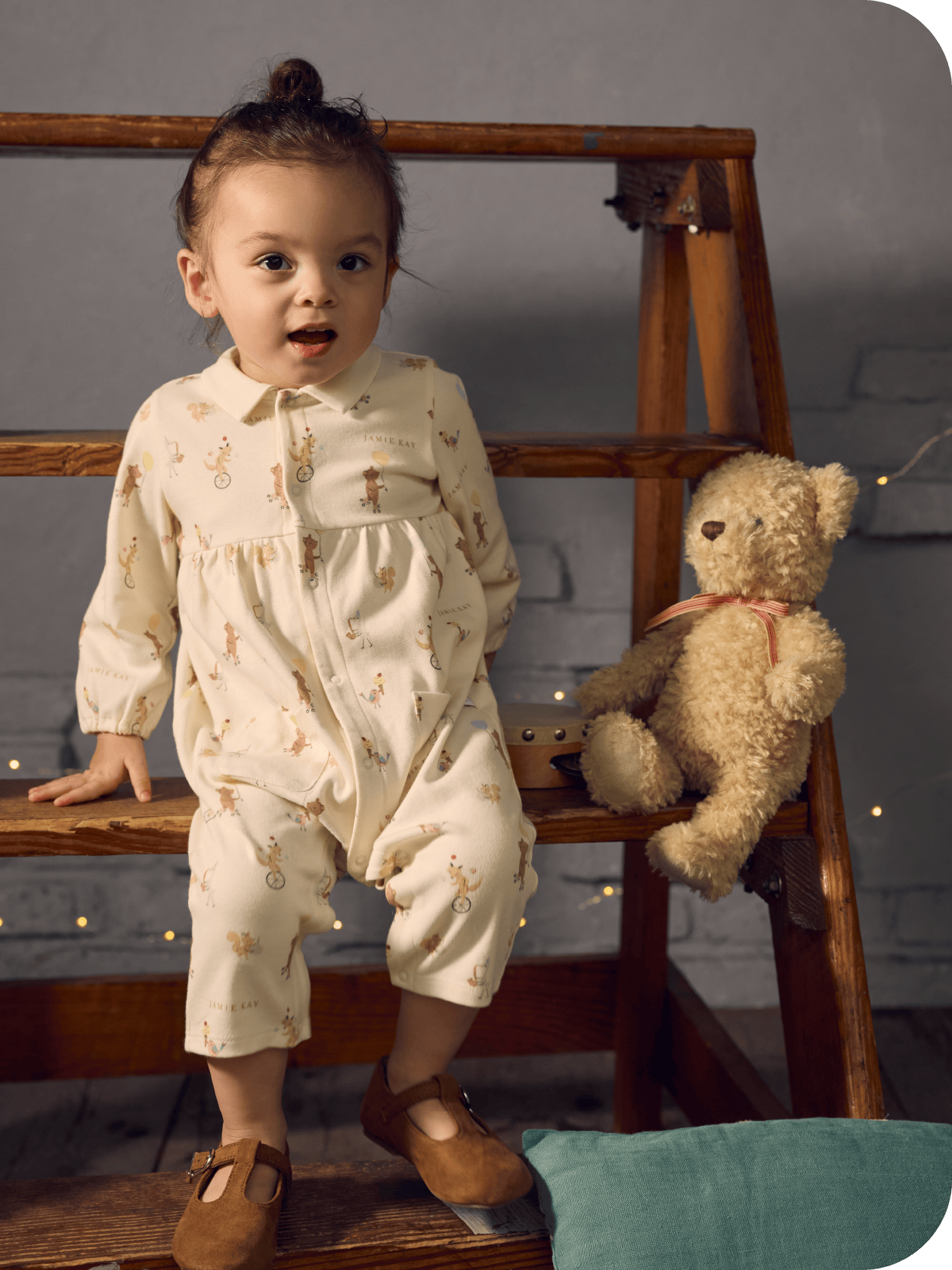 くまのぬいぐるみの横に女の子が立っている画像