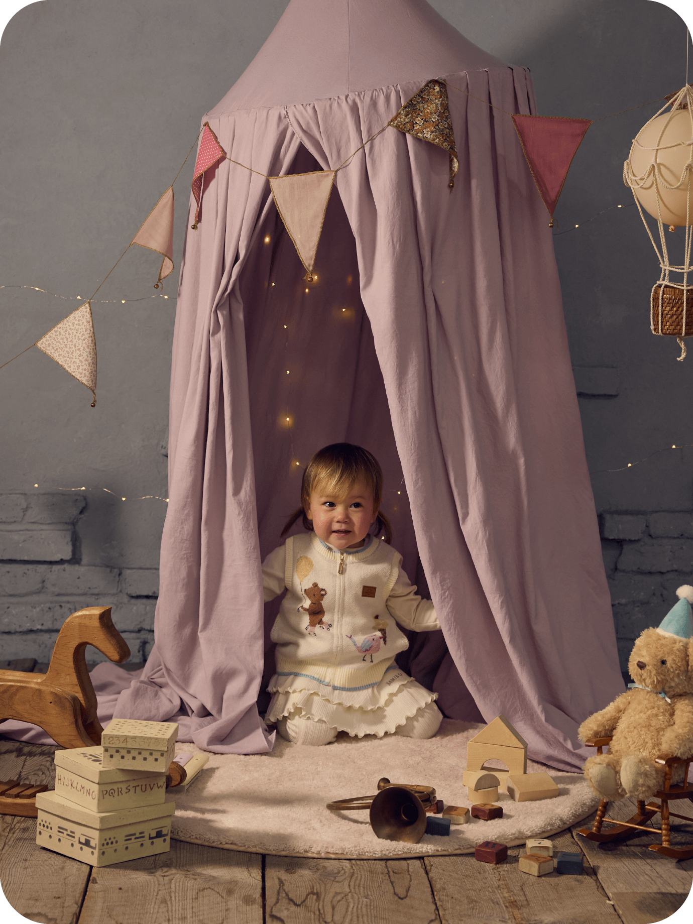 布地のテントの中に男の子が座っている画像