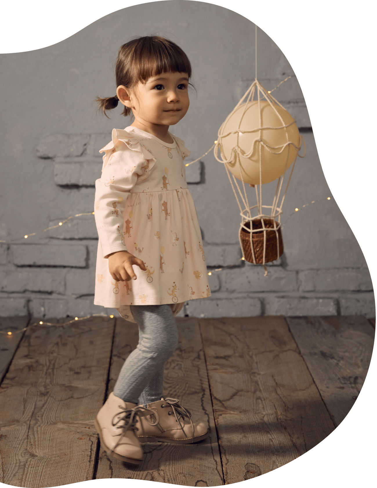 一輪車に乗ったキツネのバックプリントが入った服を着た男の子が立っている画像