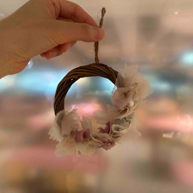 残布を使ったクリスマスリースを持った画像