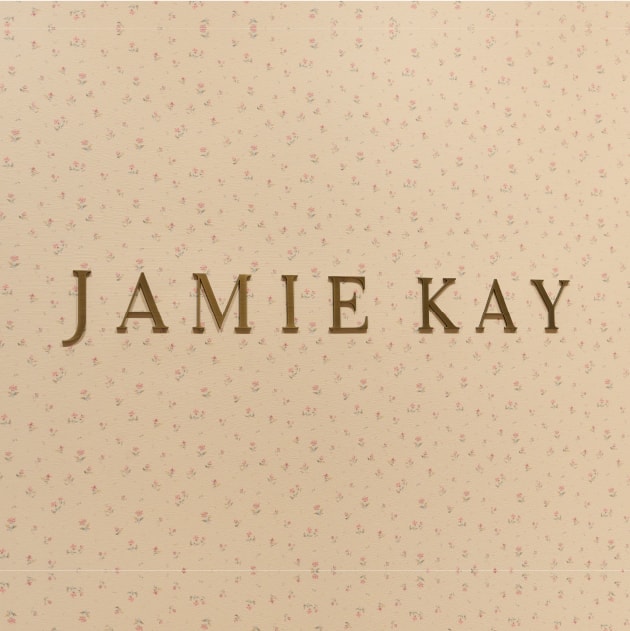 花柄の背景にJAMIE KAYのロゴが配置されている画像