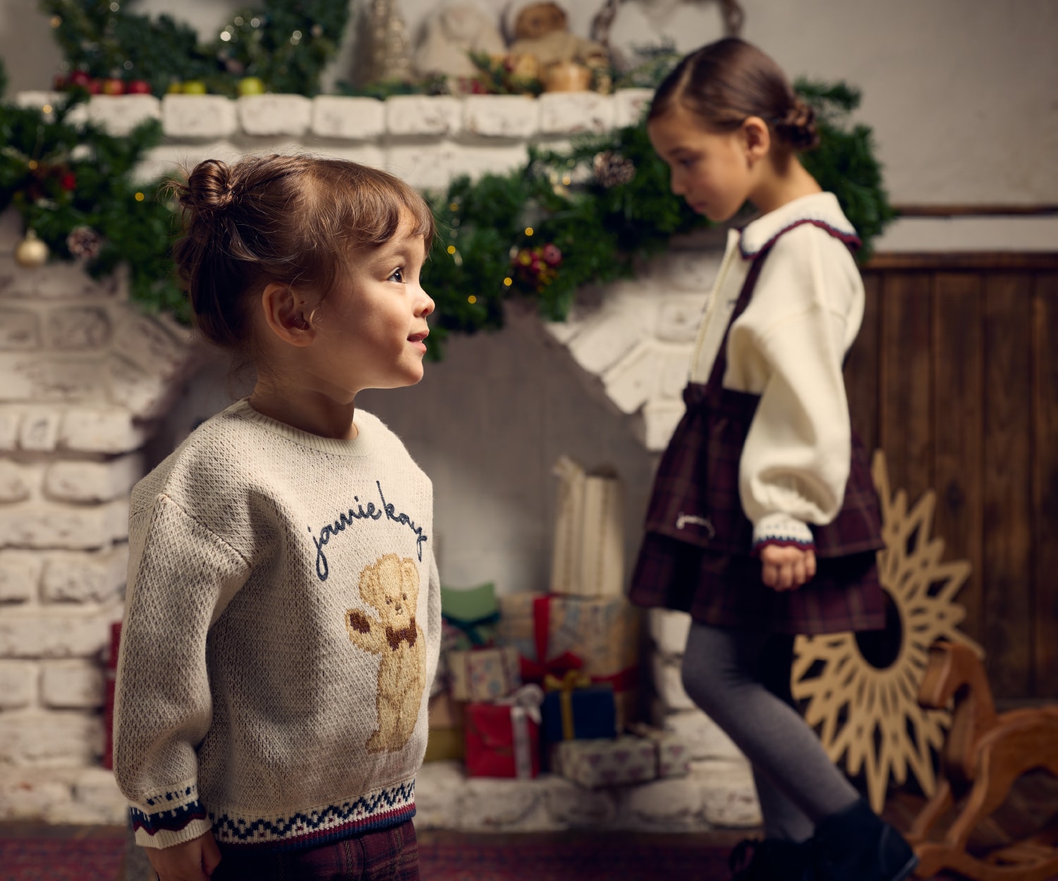 2人の子供が暖炉の前にいる画像