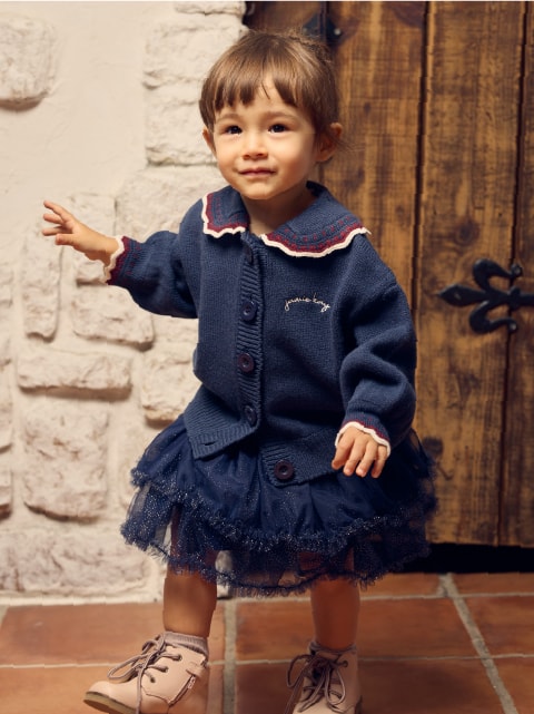 ネイビーのワンピースを着た子供が正面を向いている画像