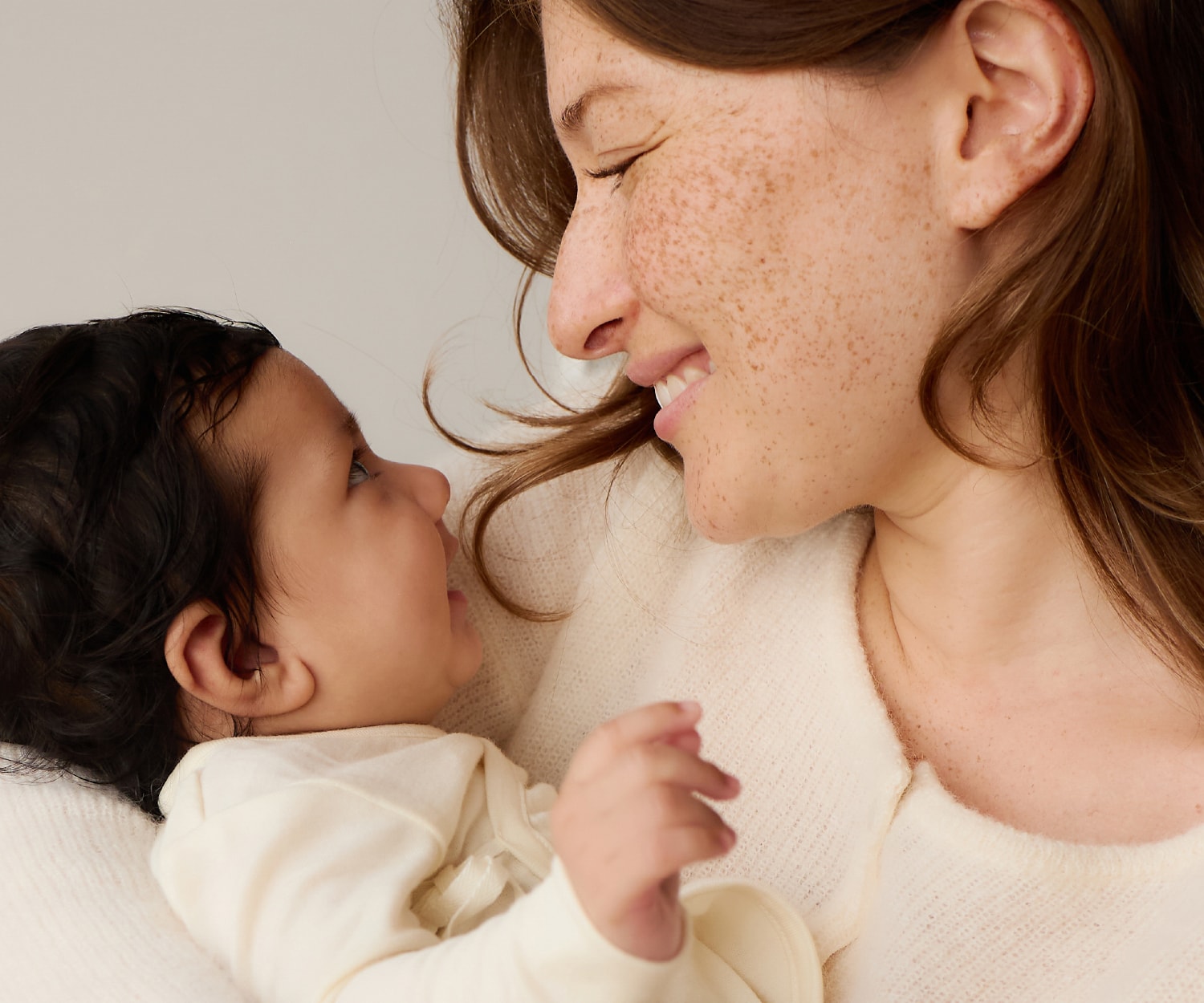 女性が赤ちゃんをだいて微笑んでいる画像