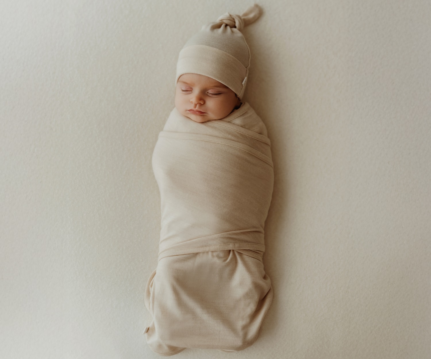 赤ちゃんがベージュの服を着ている画像