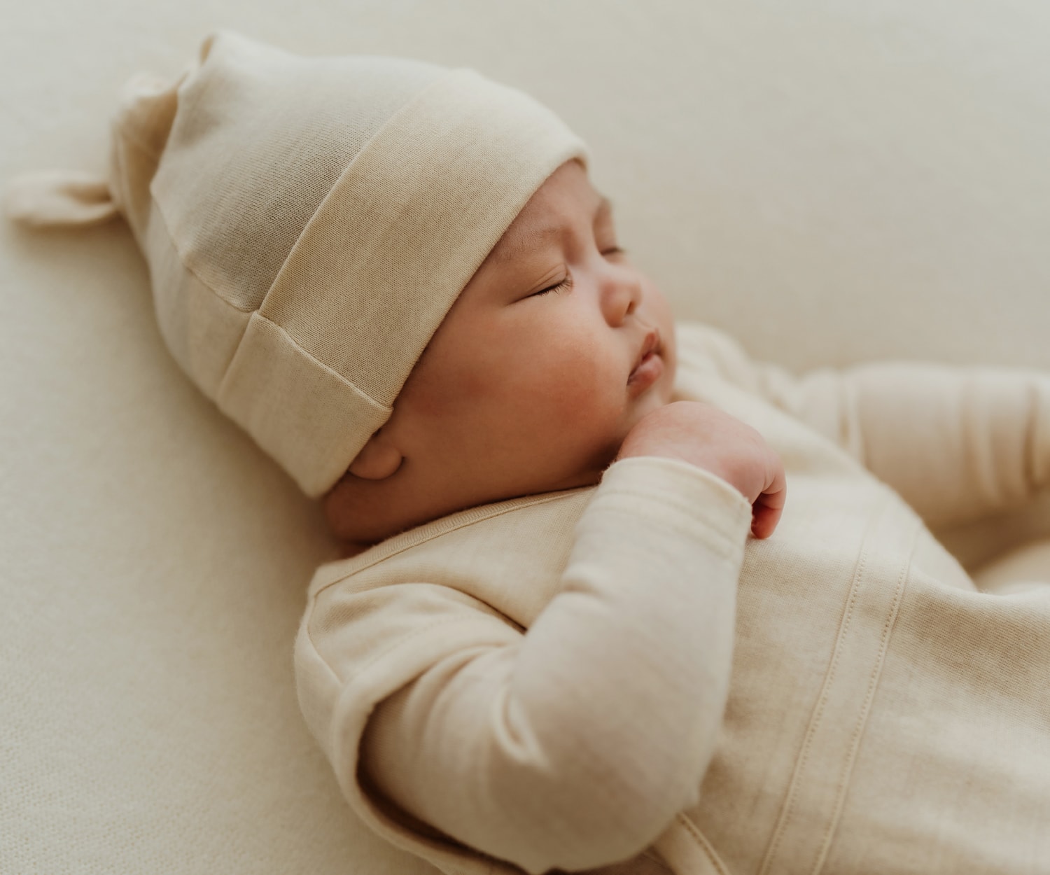 赤ちゃんがベージュの服を着ている画像